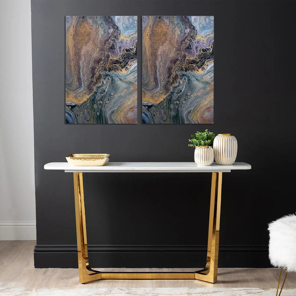 Two abstract paintings above a console table with decorative items.